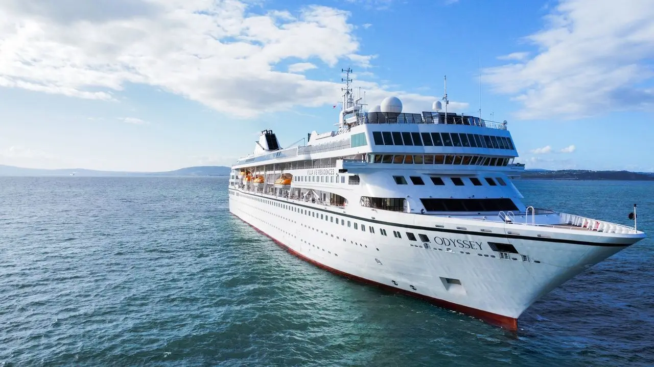 The Villa Vie Odyssey residential cruise ship sails on open water.